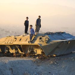 Kinder in Afghanistan spielen auf einem Panzer. Kinder spielen auf einem Panzer auf dem Bibi Maru Hill in Afghanistan.