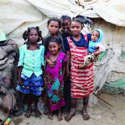 Ein jemenitisches Mädchen mit ihren fünf Schwestern vor einem Zelt in einem Flüchtlingslager.