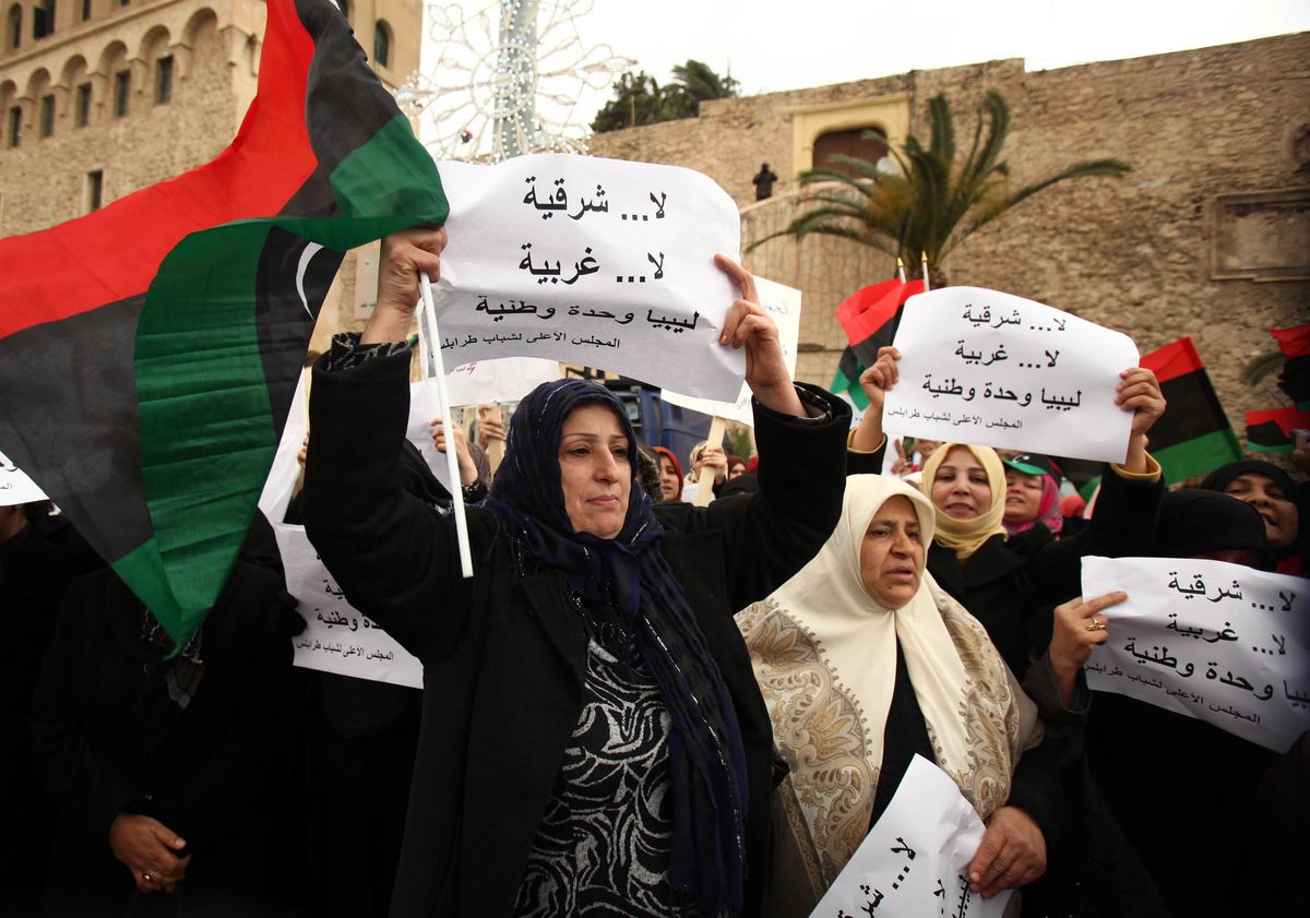 Demonstrierende Frauen mit libyscher Fahne und Plakaten in arabischer Schrift.