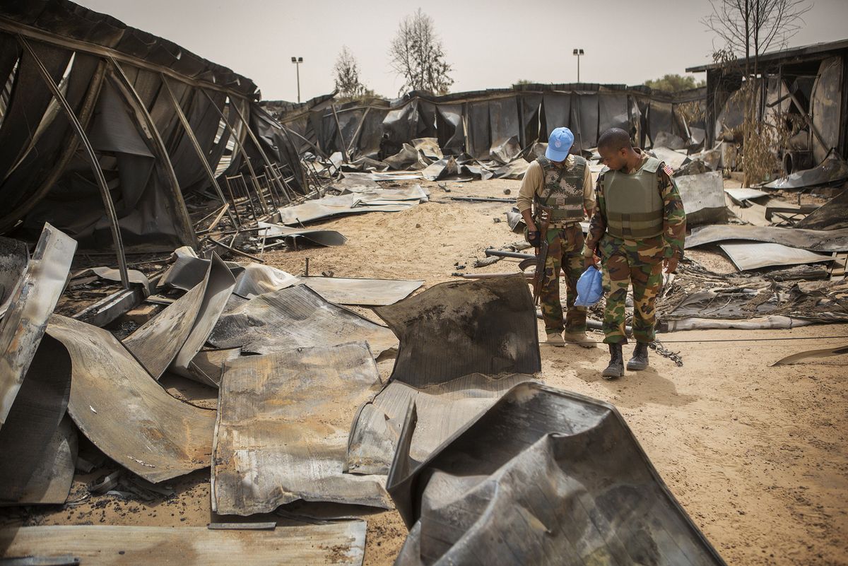 Zwei UN Soldaten gehen durch das zerstörte UN-Camp 