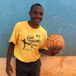 Ein Mann hält lächelnd einen Fußball in der Hand