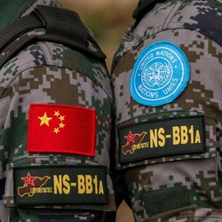 Auch chinesische Blauhelme sind Teil von UN-Friedensmissionen. Man sieht die Schultern von zwei Soldaten. Auf der einen ist eine chinesische Flagge als Abzeichen, auf der anderen das Logo der UN.