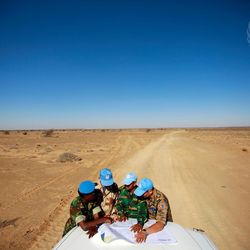 MINURSO Team schaut in der Wüste der Westsahara auf einer Karte