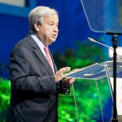 UN-Generalsekretär António Guterres hält an einem Rednerpult vor blaugrünem Hintergrund eine Rede.